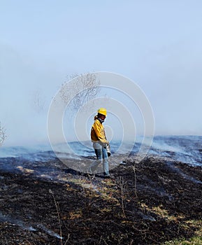 Firefighter walking through the smoldering ground