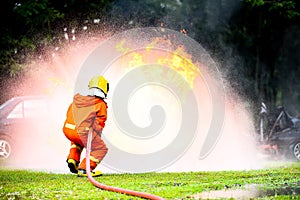 Firefighter water spray with high pressure to fire surround with damaged cars and smoke