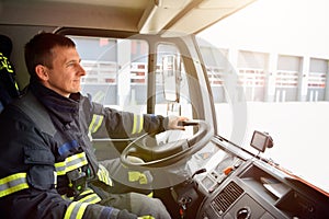 Firefighter at the wheel of an emergency vehicle drives to the scene of action and extinguishes fire