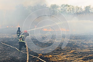 Firefighters battle a wildfire. firefighters spray water to wildfire. Australia bushfires, The fire is fueled by wind and heat