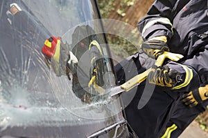 Firefighters breaking a car windscreen