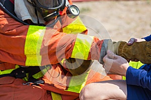 Firefighters buddy help to wearing fire protection gloves