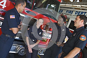 Firefighters chatting by a fire engine