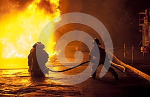 Firefighters controlling water hose