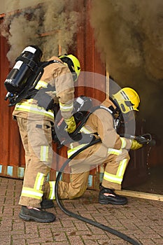 Firefighters enter a smoke filled building