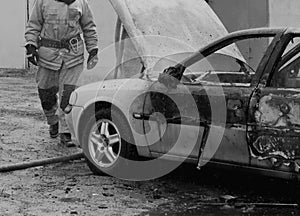 Firefighters extinguish a burning car with water, fire, extinguish, black and white