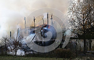 Firefighters extinguish a burning country house