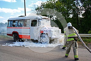 Firefighters extinguish a fire in a burning bus