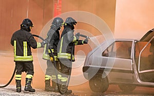 Firefighters extinguish the fire of the crashed car after the accident