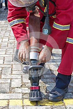 Firefighters in fire protection suit holding a water hose