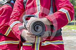 Firefighters in fire protection suit holding a water hose