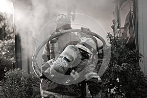 Firefighters holding hose