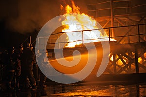 Firefighters hosing down a burning structure during firefighting exercise