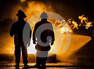 Firefighters hosing down a fire with water