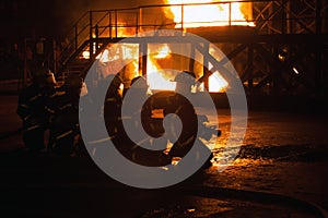 Firefighters kneeling in preparation to fight fire in firefighting exercise