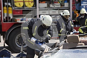 Firefighters with the pneumatic shears open the car doors