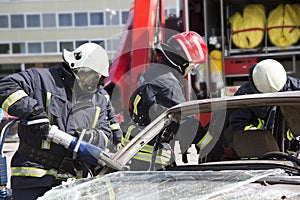 Firefighters with the pneumatic shears open the car doors