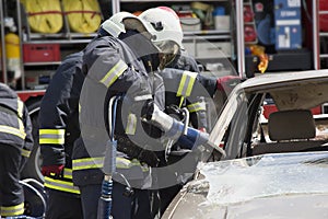 Firefighters with the pneumatic shears open the car doors