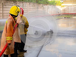 Firefighters are practicing fire fighting prevent emergencies. Use large water hose to put out the fire. The fire caused enormous