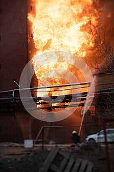 Firefighters put out large massive fire blaze, group of fire men in uniform during fire fighting operation in the city streets,