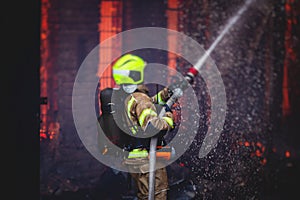 Firefighters put out large massive fire blaze, group of fire men in uniform during fire fighting operation in the city streets,