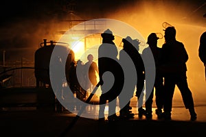 Firefighters and rescue training. Firefighter spraying high pressure water to fire Burning fire flame background.