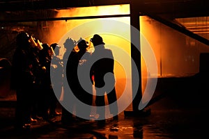 Firefighters and rescue training. Firefighter spraying high pressure water to fire Burning fire flame background.