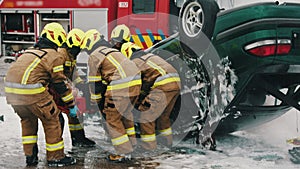 Firefighters rescuing injured person after the car accident. Slow motion