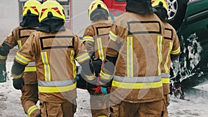 Firefighters rescuing injured person after the car accident. Slow motion