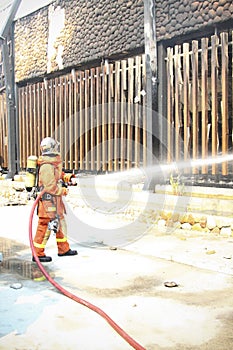 Firefighters spray water to wildfire