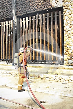 Firefighters spray water to wildfire
