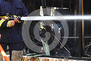 Firefighters spray water to wildfire