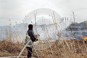 Firefighters spray water to wildfire. Fireman working hard to put out the bush fires