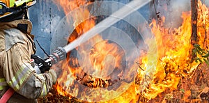 Firefighters spray water to wildfire