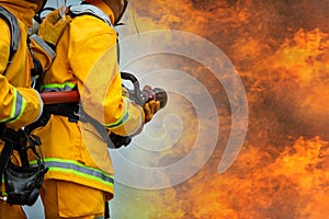 Firefighters spraying high pressure water to fire with copy space, Big bonfire in training, Firefighter wearing a fire suit for