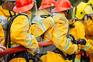 Firefighters spraying high pressure water to fire with copy space, Big bonfire in training, Firefighter wearing a fire suit for