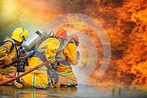 Firefighters spraying high pressure water to fire with copy space, Big bonfire in training, Firefighter wearing a fire suit for