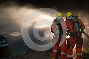 Firefighters spraying water to put out a brutal fire on the car.