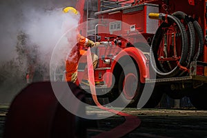 Firefighters training,Team practice to fighting with fire in emergency situation. A fireman attach hose to fire fighter vehicle