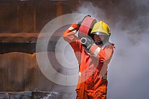 Firefighters training Team practice to fighting with fire in emergency situation. A fireman carry a water hose run through flame