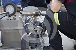 Firefighters working with a suction pump