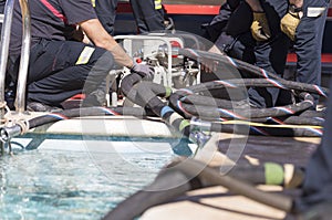 Firefighters working with a suction pump
