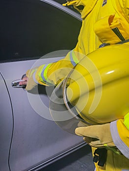 Firefighters with yellow suit holding helmet try to save life