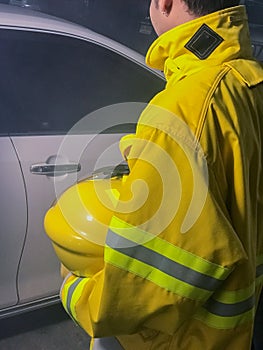 Firefighters with yellow suit holding helmet try to save life