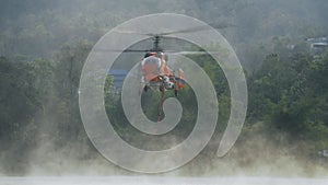 Firefighting helicopter  hovering over the pond to refills water