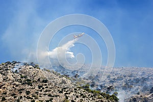 Firefighting plane extinguishes a fire on the hillside . Greece.