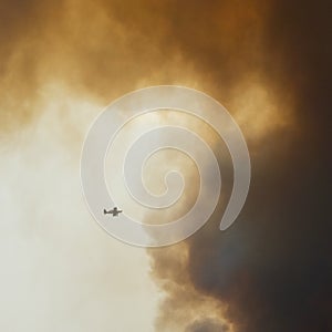 Firefighting plane flying into a large cloud of smoke