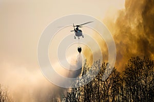 Firefithing helicopter dropping water on forest fire