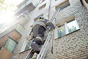 Fireman climbs stairs up in burning brick house