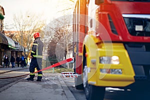 Fireman connection a firehose to a connector device. Fireman at  work